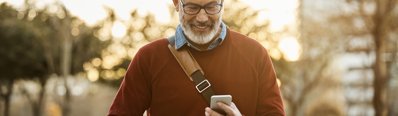 Man looking at phone while walking with bike